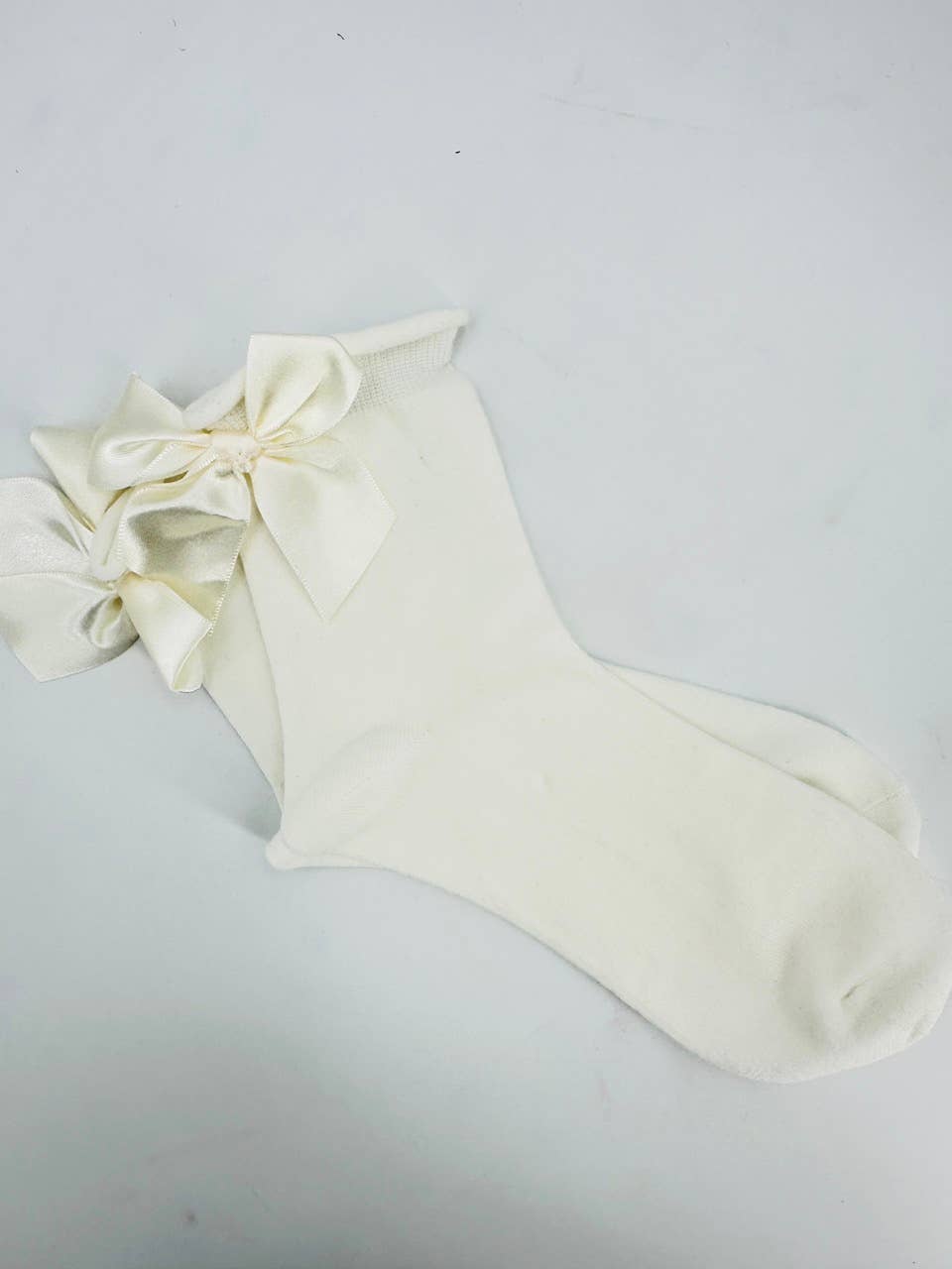 Elisa weiße Socken mit einer marineblauen Satinschleife
