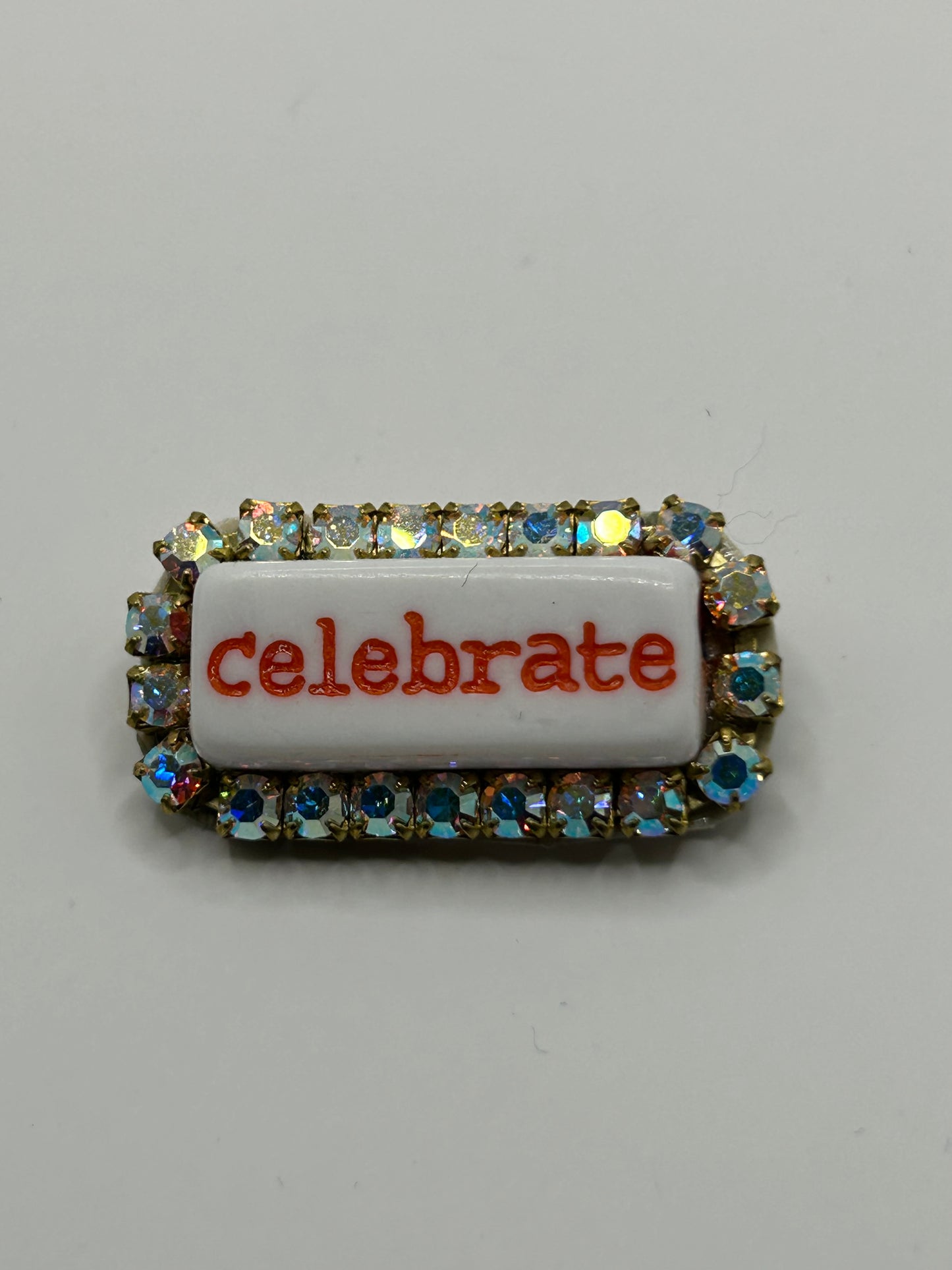 Tezee Statement-Brosche „celebrate“ – Funkelnde Strassbrosche mit Schriftzug